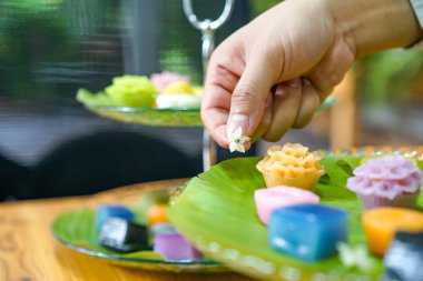 Tayland Şefi 'nin eli çeşitli dekore ediyor geleneksel renkli Tayland tatlıları; buharda pişmiş un, kara muhallebi, hindistan cevizi kreması ve buharda pişmiş fasulye, katmanlı puding