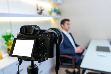 Bangkok, Tayland - 25 Ekim 2019: Sony A7 işaret 3 (A7iii) arka taraftaki tripodla kaydeden İşadamı ile odasında röportaj yapıldı. Bangkok, Tayland