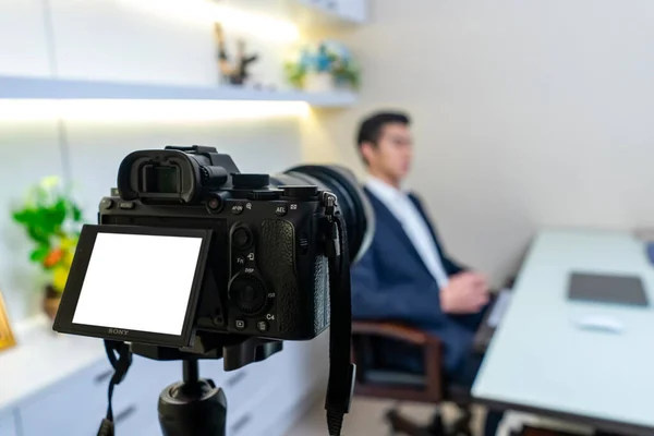 Bangkok, Tayland - 25 Ekim 2019: Sony A7 işaret 3 (A7iii) arka taraftaki tripodla kaydeden İşadamı ile odasında röportaj yapıldı. Bangkok, Tayland