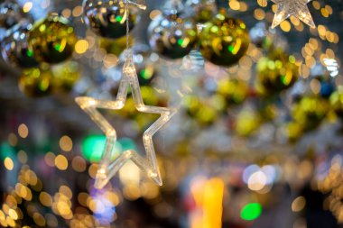 Ilık açık sarı ve turuncu yıldız şekli halka üzerinde parıldıyor Bokeh festival veya kart arka planı için tavana tutunun.