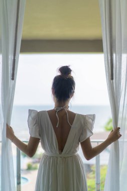 Tayland gril elbisesi ling whirt kıyafet kuralları önünde duruyor yatak odası terası önünde kaynayan havuz ve hayalî deniz manzaralı.