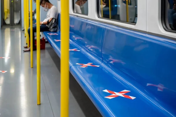 blue seat row in the train with crossed marking tape in Coronavirus (COVID-19) period. It means Social Distancing in transportation.