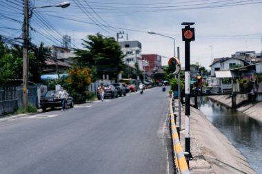 Tayland 'ın doğusundaki Chonburi vilayetindeki yol ve kanal arasında sadece kırmızı ışık bulunan trafik direği..