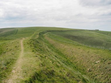 Wansdyke, Wiltshire, İngiltere 'nin devasa antik doğrusal toprak çalışmaları boyunca Tan Hill' e doğru bakıyoruz.