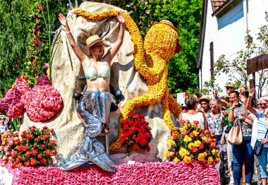 STEINFURTH, GERMANY-JULY 15, 2018: On every even-numbered year, the Bad Nauheim suburb Steinfurth, the oldest rose village in Germany, honours the rose by celebrating the rose festival, the highlight is the Rosenkorso with its magnificent floats. clipart