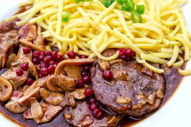 Kızılcık ve ev yapımı spaetzle ile kavrulmuş geyik ve yaban domuzu