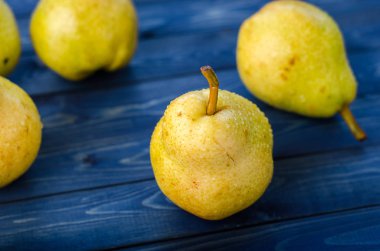 Ahşap rustik mavi zemin üzerine olgun sarı armut. Yaz meyve, hasat.