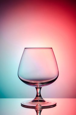 Boş bardak konyak renk, degrade arka plan için. Ayna yüzey. Konsept: parlak, neşeli, kulüp hayat. 