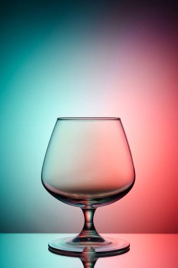 Boş bardak konyak renk, degrade arka plan için. Ayna yüzey. Konsept: parlak, neşeli, kulüp hayat. 