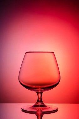 Boş bardak konyak renk, degrade arka plan için. Ayna yüzey. Konsept: parlak, neşeli, kulüp hayat. 