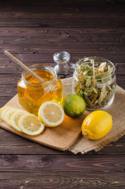 limon ve koyu ahşap arka plan üzerine bir bardak ballı bitki çayı