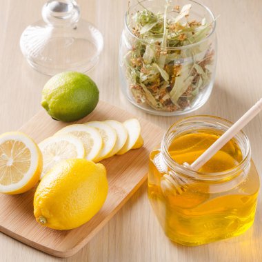 limon ve hafif karanlık bir arka plan üzerinde bir bardak ballı bitki çayı