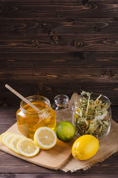 レモンと暗い背景の木にガラスに蜂蜜とハーブティー — ストック写真