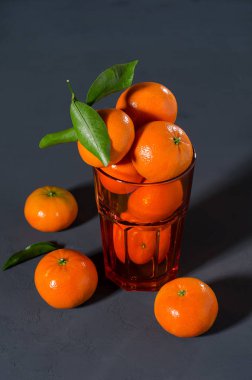 Mandalina portakal bir cam siyah bir zemin üzerine. Kış narenciye.