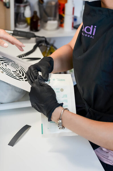 Evpatoria, Russia - July 31, 2018. The manicure master opens a crafting bag with a sterilized tool. Concept: safe visiting a beauty salon, a guarantee against infection and viruses