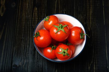Olgun, taze domates karanlık rustik ahşap arka plan üzerinde. Organik, sağlıklı, ham, vejetaryen yemek.