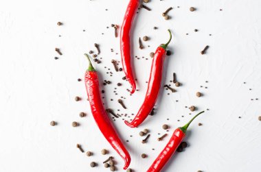 Beyaz zemin üzerine biber. Baharatlar: siyah hardal tohumu, karanfil, kırmızı biber, karabiber, yenibahar.