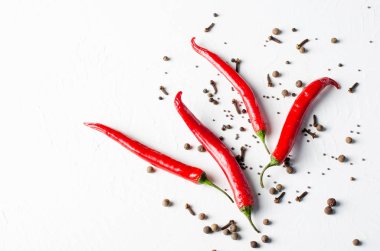 Beyaz zemin üzerine biber. Baharatlar: siyah hardal tohumu, karanfil, kırmızı biber, karabiber, yenibahar.