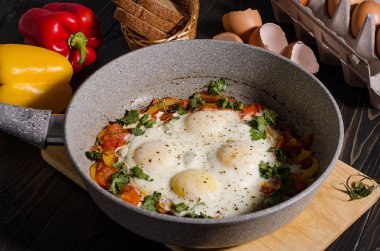 Çırpılmış yumurta ile bir tavada bir rustik karanlık tabloda tatlı biber.