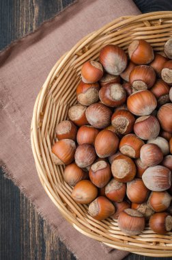 Bir karanlık, rustik, ahşap arka planda bir kil kase fındık.