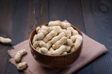 Ahşap kase bir karanlık, rustik, ahşap arka plan kabuğuna fıstık.