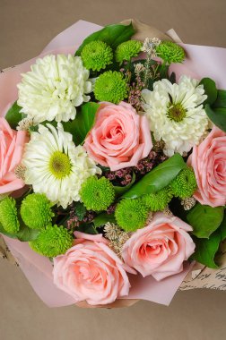 Kraft kağıt bej renkli bir arka plan üzerine gül buketi.