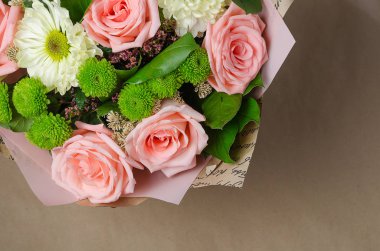 Kraft kağıt bej renkli bir arka plan üzerine gül buketi.