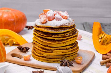 Bir yığın üzerinde üst ve şekerlenmiş Kamkat hafif bir arka plan üzerine pudra şekeri ile ev yapımı kabak punkcakes.