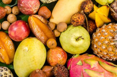 Koyu ahşap rustik arka plan üzerinde çeşitli Tay tropik meyveler.