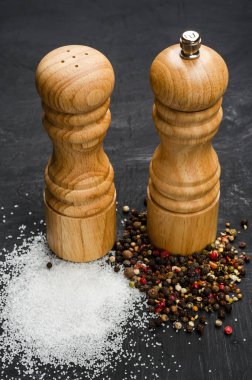 Ahşap tuzluk ve pepperbox siyah tebeşir tahtası üzerinde.