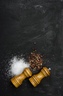 Ahşap tuzluk ve pepperbox siyah tebeşir tahtası üzerinde.