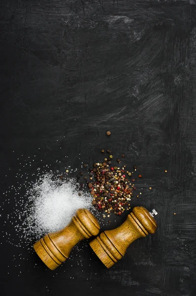 Ahşap tuzluk ve pepperbox siyah tebeşir tahtası üzerinde.