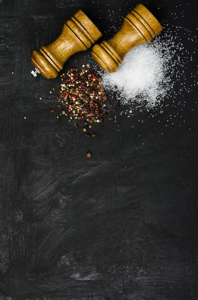 Ahşap tuzluk ve pepperbox siyah tebeşir tahtası üzerinde.