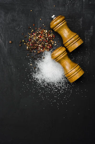 Wooden salt and pepper shaker. Seasoning salt and pepper on black chalk board. Menu cover.