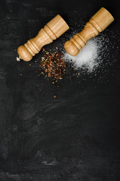 Ahşap tuzluk ve pepperbox siyah tebeşir tahtası üzerinde.