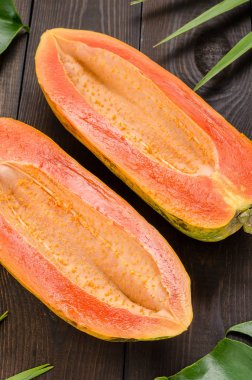 Karanlık bir arka plan üzerinde olgunlaşmış papaya.