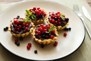 Masa örtüsü üzerinde krem çikolata ile lezzetli sulu berry kek. Yan görünüm