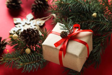 Noel kompozisyon kırmızı bir arka plan üzerinde. Xmas süslemeleri. Noel hediyesi, çam kozalakları, çam dalları.