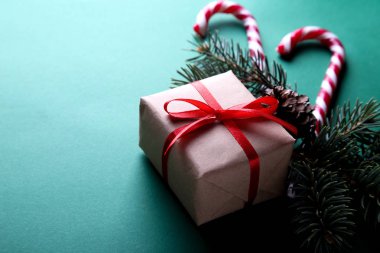 Yeşil bir arka plan üzerinde Noel kompozisyon. Noel hediyesi, süslemeleri, çam dalları. Metin alanı ile yakın çekim