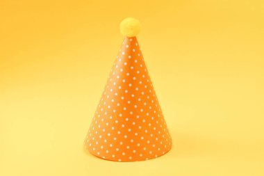 Sarı arka planda sarı doğum günü şapkası. Kopyalama alanı.