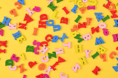 Sarı arka planda çok renkli harfler.