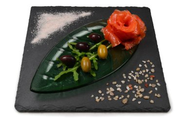 Beyaz üzerine tuz ve zeytinli bir tabakta somon dilimleri..