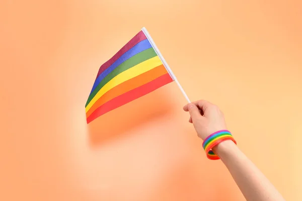 ЛГБТ прапор у жінки руку на помаранчевому фоні. Копіювати пробіл. — стокове фото