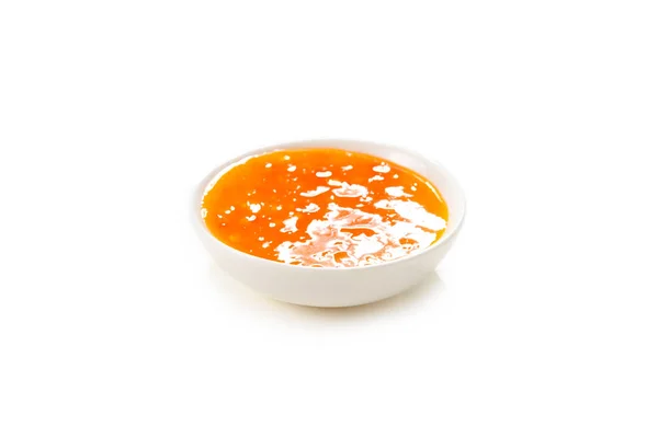 Sauce orange dans une assiette blanche sur fond blanc. — Photo