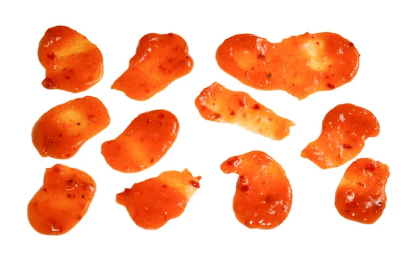 Orange spicy sauce splashes isolated on white background.