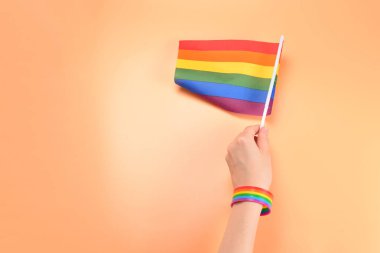 Turuncu arka planda kadın el LGBT bayrağı. Boşluk Kopyala. 