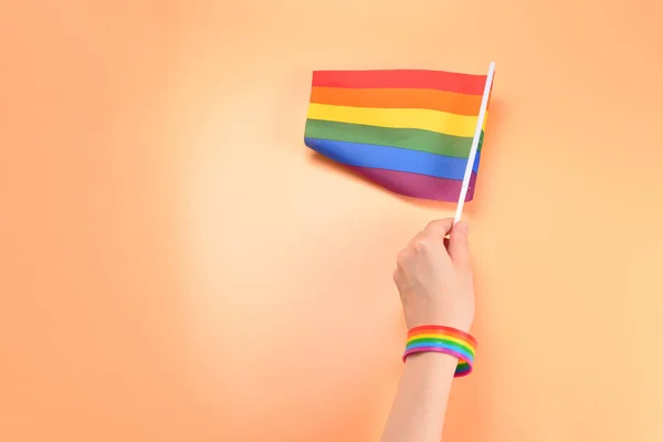 ЛГБТ прапор у жінки руку на помаранчевому фоні. Копіювати пробіл. — стокове фото