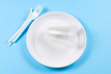 Mavi arka planda plastik tabaklar. Tek kullanımlık sofra takımları