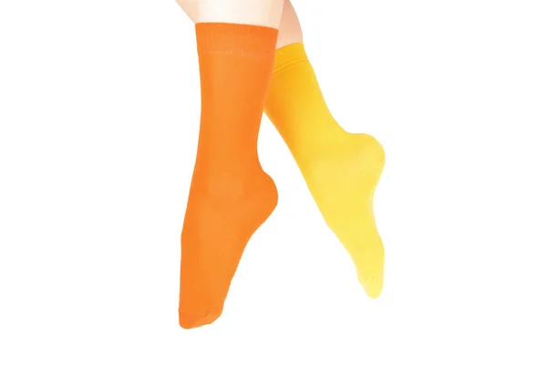 Gelbe und orangefarbene Socken am Frauenfuß isoliert auf weißem Hintergrund — Stockfoto