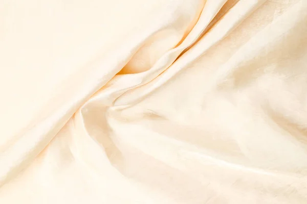 Mjuk mjuk beige silke tyg bakgrund. Tygstruktur. — Stockfoto